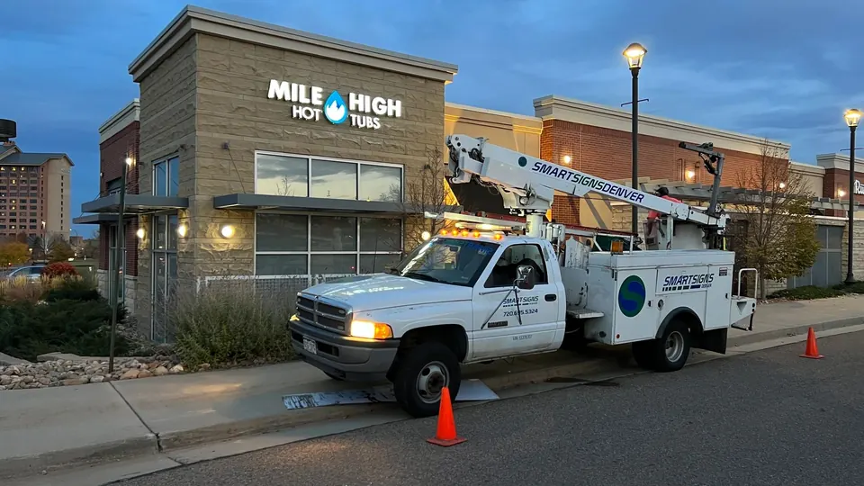 Smart Sign Denver bucket truck parked at a commercial job site at dusk